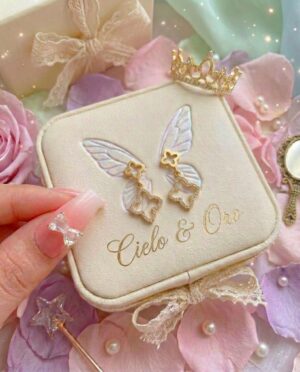 Firefly_GeminiFlash_sustituye en la foto donde esta la caja de Cielo & Oro sustituye esos anillo por los 733127 Aretes de trevol enchapado oro real 18k